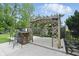 Backyard pergola with seating offers a great relaxation and entertainment space, set on a concrete patio and surrounded by greenery at 6825 Farmleigh Dr, Indianapolis, IN 46220