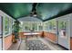 Inviting sunroom featuring windows, ceiling fan, and views of the lush backyard at 6825 Farmleigh Dr, Indianapolis, IN 46220