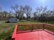 View from a red deck to the backyard, revealing the large trees, blue sky and additional building at 6985 E County 100 S Rd, Avon, IN 46123