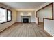 Spacious living room featuring a stone fireplace, large window, and wood-look flooring at 6985 E County 100 S Rd, Avon, IN 46123