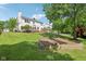 A spacious backyard with raised garden beds, and a view of the home's rear exterior and wooden deck at 7388 Wythe Dr, Noblesville, IN 46062