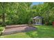 A charming backyard shed complemented by raised garden beds, framed by lush greenery and a well-maintained lawn at 7388 Wythe Dr, Noblesville, IN 46062