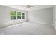 A bright bedroom features plush carpet, a ceiling fan, and a large window at 7388 Wythe Dr, Noblesville, IN 46062