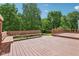 An expansive wooden deck features a built-in bench, offering ample seating and scenic views of the green yard at 7388 Wythe Dr, Noblesville, IN 46062