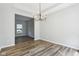 A simple dining room featuring wood-look floors and a stylish six-light chandelier at 7388 Wythe Dr, Noblesville, IN 46062