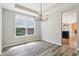 Dining room boasts a modern chandelier, large windows, and hardwood flooring at 7388 Wythe Dr, Noblesville, IN 46062
