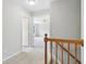 Upstairs hallway featuring a wood banister and a view into the bedrooms at 7388 Wythe Dr, Noblesville, IN 46062