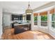 Charming kitchen features an island, stainless appliances, dark cabinetry, and sunlit breakfast nook at 7388 Wythe Dr, Noblesville, IN 46062
