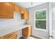 An office space with built in desk, upper cabinets, and a window overlooking foliage at 7388 Wythe Dr, Noblesville, IN 46062