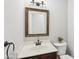 Traditional powder room featuring a wood vanity, framed mirror, and bronze fixtures at 7388 Wythe Dr, Noblesville, IN 46062