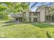 Spacious backyard featuring a deck, patio, lush green grass, and mature trees offering shade at 8047 Van Ness Way, Indianapolis, IN 46240