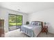 Bright bedroom with a sliding door to the outside, carpeted floors, and a comfortable queen-sized bed at 8047 Van Ness Way, Indianapolis, IN 46240