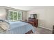 Bright bedroom featuring a wooden bed, view of the yard, and a TV on top of a wooden dresser at 8047 Van Ness Way, Indianapolis, IN 46240