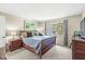 Cozy bedroom with a wooden bed frame, neutral walls, and a bright window at 8047 Van Ness Way, Indianapolis, IN 46240
