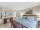 Cozy bedroom featuring a light blue bedspread and framed paintings above a desk and the headboard at 8047 Van Ness Way, Indianapolis, IN 46240
