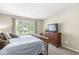 Bright bedroom showcasing a window view and wooden dresser at 8047 Van Ness Way, Indianapolis, IN 46240