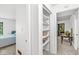 Hallway with a closet and view of a bedroom with a bed and a desk, and a light-filled hallway at 8047 Van Ness Way, Indianapolis, IN 46240