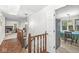 Hallway showcasing wood railing and floors leading to the living room and open dining area with ample natural light at 8047 Van Ness Way, Indianapolis, IN 46240