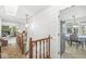 Well-lit hallway with wood railings and view of living area and dining room at 8047 Van Ness Way, Indianapolis, IN 46240