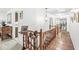 Upstairs hallway features wooden floors and rails, with a view of the rooms through the house at 8047 Van Ness Way, Indianapolis, IN 46240