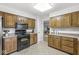 Functional kitchen featuring wood cabinets, a black range, and easy access to adjacent rooms at 8047 Van Ness Way, Indianapolis, IN 46240