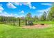 Large, grassy backyard featuring a fenced-in garden area and a brick fire pit at 8820 Mud Creek Rd, Indianapolis, IN 46256