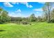 Expansive backyard with lush green grass, mature trees, and a charming fire pit area at 8820 Mud Creek Rd, Indianapolis, IN 46256