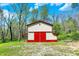 A well-maintained barn with red trim stands out against the green landscape, offering ample space with a country charm at 8820 Mud Creek Rd, Indianapolis, IN 46256