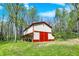 The barn features a striking red and white exterior, complemented by lush green surroundings for a rustic aesthetic at 8820 Mud Creek Rd, Indianapolis, IN 46256
