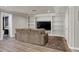 Finished basement featuring plank flooring, a large TV wall unit, and a comfortable lounge area at 8820 Mud Creek Rd, Indianapolis, IN 46256
