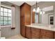 Bright bathroom featuring a wood cabinet, stone countertop, large mirror, and a window view at 8820 Mud Creek Rd, Indianapolis, IN 46256