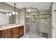 Bathroom featuring a glass enclosed shower with stone floor, vanity with stone countertop and stylish light fixture at 8820 Mud Creek Rd, Indianapolis, IN 46256