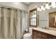 Charming bathroom with a wood-framed window, modern vanity, and a neutral-toned shower curtain at 8820 Mud Creek Rd, Indianapolis, IN 46256