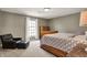 Comfortable bedroom featuring a sleigh bed, chair with ottoman, and ample natural light from the window at 8820 Mud Creek Rd, Indianapolis, IN 46256