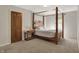 Bedroom features a 4-poster bed, side table, soft carpet, and closet access door at 8820 Mud Creek Rd, Indianapolis, IN 46256