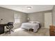Cozy bedroom features a gray accent wall, a window view, and a desk area for work or study at 8820 Mud Creek Rd, Indianapolis, IN 46256