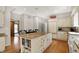 Spacious kitchen features an island with granite countertops, seating, built in bookshelves, and custom white cabinets at 8820 Mud Creek Rd, Indianapolis, IN 46256