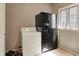 Functional laundry area with dryer, refrigerator, and natural light from a window at 8820 Mud Creek Rd, Indianapolis, IN 46256
