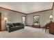 Cozy living room with large windows, classic wood trim, and plush carpet at 8820 Mud Creek Rd, Indianapolis, IN 46256
