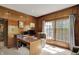 Wood-paneled office featuring custom hardwood trim, large bay window, and a glass desk for a sophisticated workspace at 8820 Mud Creek Rd, Indianapolis, IN 46256