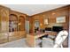Well-appointed office featuring built-in bookshelves, wood trim, and a comfortable chair beside a glass-top desk at 8820 Mud Creek Rd, Indianapolis, IN 46256