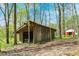 The outbuilding sits among mature trees, blending with nature, offering ample outdoor storage or workshop space at 8820 Mud Creek Rd, Indianapolis, IN 46256