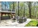 An outdoor patio features a seating area surrounded by lush greenery and mature trees at 8820 Mud Creek Rd, Indianapolis, IN 46256
