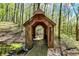 Rustic wooden playhouse in the woods featuring a creek, creating an enchanting retreat at 8820 Mud Creek Rd, Indianapolis, IN 46256