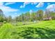 Picturesque view of the property with a large, grassy area, garden, and wooded backdrop at 8820 Mud Creek Rd, Indianapolis, IN 46256