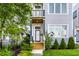 Inviting front entrance with wood porch, stylish door and manicured landscaping at 952 Elm St, Indianapolis, IN 46203
