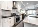 Modern kitchen featuring white cabinets, stainless steel appliances, and stylish backsplash at 952 Elm St, Indianapolis, IN 46203