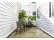 Outdoor patio featuring a small table and chairs, surrounded by white siding and a small tree at 952 Elm St, Indianapolis, IN 46203