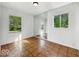 Bright bedroom with hardwood floors, white walls, and two windows at 9526 Burrwood Ct, Indianapolis, IN 46235