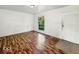 A cozy bedroom with wood-look flooring, a bright window, and neutral paint at 9526 Burrwood Ct, Indianapolis, IN 46235